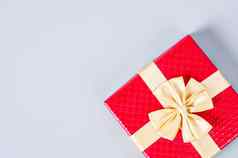 红色的礼物盒子黄金丝带灰色的背景