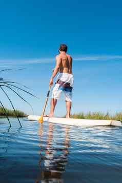 男人。站paddleboarding