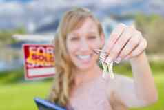 兴奋女人持有房子键出售真正的房地产标志前面不错的首页