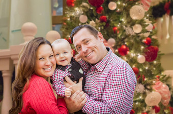 快乐年轻的<strong>父母</strong>婴儿前面装饰圣诞<strong>节</strong>树