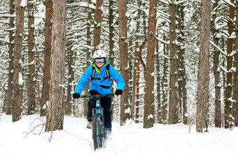 骑自行车的人蓝色的骑山自行车美丽的冬天森林极端的体育运动复古骑自行车概念
