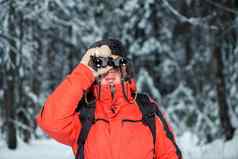 失去了旅游男人。冬天森林双筒望远镜