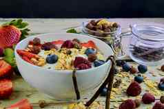 健康的早餐麦片酸奶草莓蓝莓树莓牛奶什锦早餐木乡村背景概念健身饮食健康早餐
