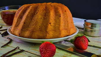 成形沙子蛋糕杯黑色的茶块香草木背景蛋黄海绵蛋糕的草莓乡村白色背景