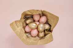 复活节鸡蛋木碗粉红色的黄金复活节鸡蛋粉红色的柔和的复活节概念鸡蛋羽毛古董报纸