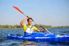 年轻的专业皮划艇爱好者划皮艇河明亮的早....太阳体育运动活跃的生活方式概念