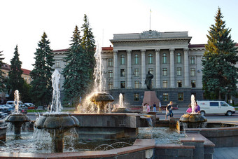 迷人的喷泉主要街道城市前面教育机构位于美丽的建筑列纪念碑前面入口高郁郁葱葱的树墙