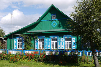 蓝色的绿松石木房子百叶窗画栅栏花树蓝色的多云的天空的地方休息旅游