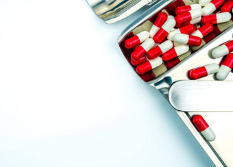 前视图红色的白色抗生素胶囊药片不锈钢钢药物托盘药物电阻抗生素药物合理的健康政策健康保险概念制药行业药店背景