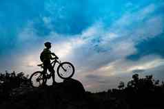 轮廓骑自行车的人山自行车岩石日落极端的体育复古骑自行车概念