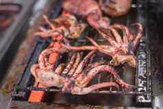 新鲜的鱿鱼触手燃烧的亚洲当地的市场烧烤站美国