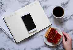 女人规划一天咖啡华夫饼大理石背景智能手机