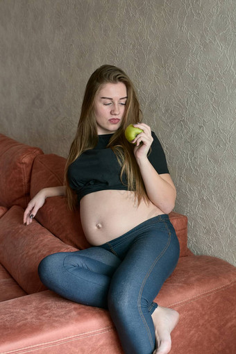 年轻的怀孕了女人怀孕了美丽的女人绿色苹果摆姿势首页快乐怀孕