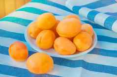 新鲜的成熟的杏子白色板条纹桌布阳光明媚的夏天一天阳台