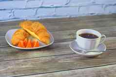 光早餐黑色的咖啡羊角面包片橙色特写镜头