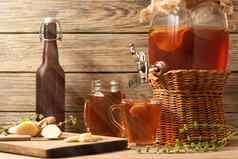 新鲜的自制的红茶菌发酵茶喝Jar水龙头cans-mugs杯木背景