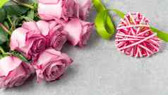 花安排花束粉红色的玫瑰柳条心灰色混凝土表面模板设计问候卡的地方文本复制空间
