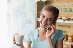 女人喝咖啡移动电话咖啡商店