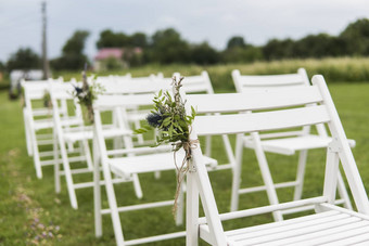 白色婚礼椅子装饰新鲜的花绿色草空木椅子客人绿色草坪上花园准备婚礼仪式