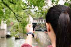 年轻的女人有趣的当地的运河城市中国相机