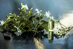 关闭本质至关重要的石油印度茉莉花花朱希素馨属耳廓孤立的白色小透明的玻璃瓶生花