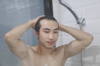特写镜头年轻的男人。洗头发洗发水浴室