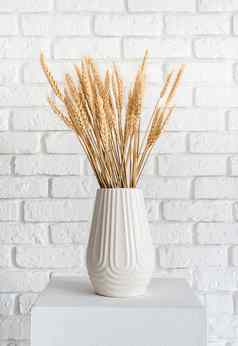小麦峰值白色花瓶白色砖墙背景