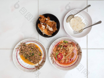 前视图<strong>木瓜沙拉</strong>辣的剁碎猪肉炸鸡黏糊糊的大米泰国当地的食物