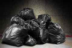 垃圾桩很多转储垃圾塑料袋黑色的浪费混凝土墙污染垃圾塑料浪费垃圾袋本塑料浪费桩垃圾浪费很多垃圾转储