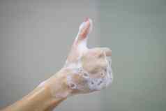 手软泡沫泡沫肥皂显示拇指