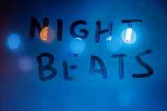 单词晚上垮掉的一代手写的湿窗口玻璃夜间蓝色的光颜色