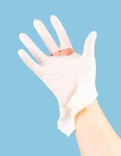 破碎的白色乳胶外科医生医疗手套高加索人手孤立的蓝色的纯色背景