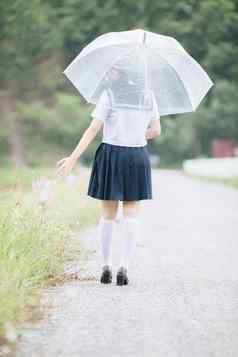 肖像亚洲学校女孩走伞自然