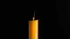 特写镜头黄色的蜡烛照亮黑色的背景
