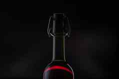 玫瑰酒红色的酒瓶金属开瓶器软木塞黑暗背景