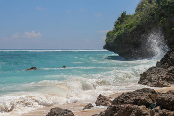 海滩山伞海滩细金沙子巴厘岛绿<strong>松石</strong>蓝色的水转海泡沫波打破岩石悬崖海岸阳光明媚的一天蓝色的天空旅游自然概念