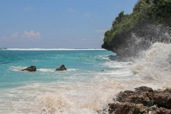 海滩山伞海滩细金沙子巴厘岛绿<strong>松石</strong>蓝色的水转海泡沫波打破岩石悬崖海岸阳光明媚的一天蓝色的天空旅游自然概念