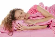 快乐年轻的女人睡觉粉红色的床上