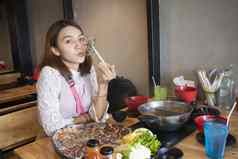 年轻的亚洲女人享受吃涮涮锅日本热能