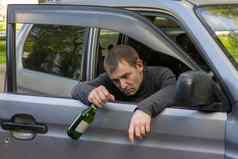 喝醉了不负责任的司机挂门车瓶含酒精的饮料