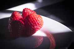 成熟的草莓白色板黑暗背景