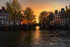日落阿姆斯特丹房子运河反映了水运河阿姆斯特丹荷兰