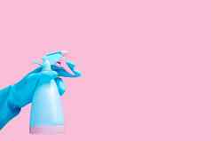 手蓝色的橡胶手套持有清洁喷雾瓶洗涤剂孤立的粉红色的背景复制空间文本标志