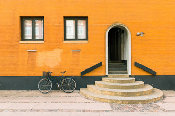 黑色的自行车橙黄色的墙住宅布莱克自行车橙黄色的墙住宅建筑哥本哈根丹麦