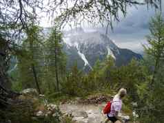 年轻的女人山前面阿尔卑斯山脉意大利白云石山脉年轻的女孩旅行者坐着视图白云石山脉阿尔卑斯山脉意大利享受视图捕获行动相机