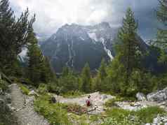 年轻的女人山前面阿尔卑斯山脉意大利白云石山脉年轻的女孩旅行者坐着视图白云石山脉阿尔卑斯山脉意大利享受视图捕获行动相机