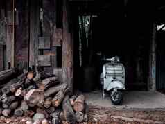 白色古董维斯帕电动机踏板车停车木小屋