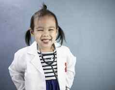 亚洲女孩角色玩医生占领穿白色礼服统一的微笑玩学习孩子们
