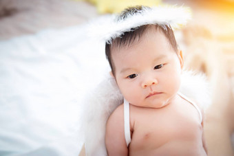 特写镜头美丽的新生儿婴儿女孩肖像美丽的新生儿婴儿女孩穿天使翅膀天使环