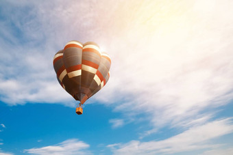 旅行旅游概念色彩斑斓的热空气<strong>气球飞行</strong>日出多云的蓝色的天空背景